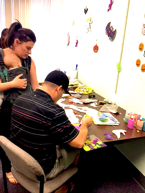 A father is making a book for his child.